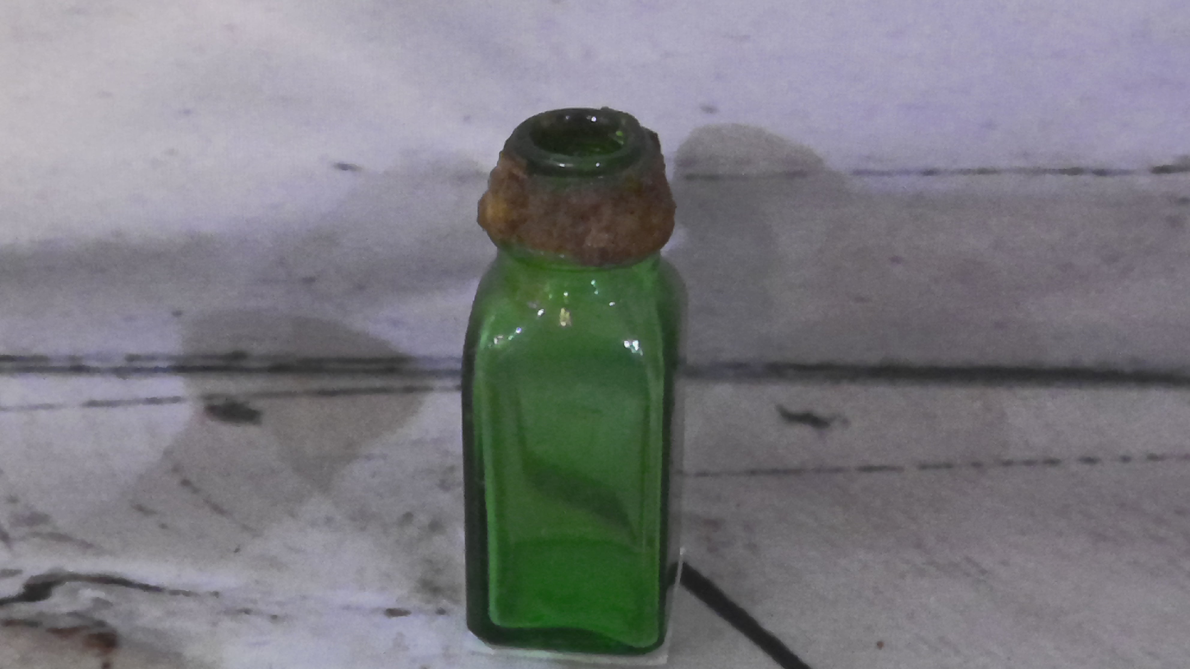 Very small green bottle
