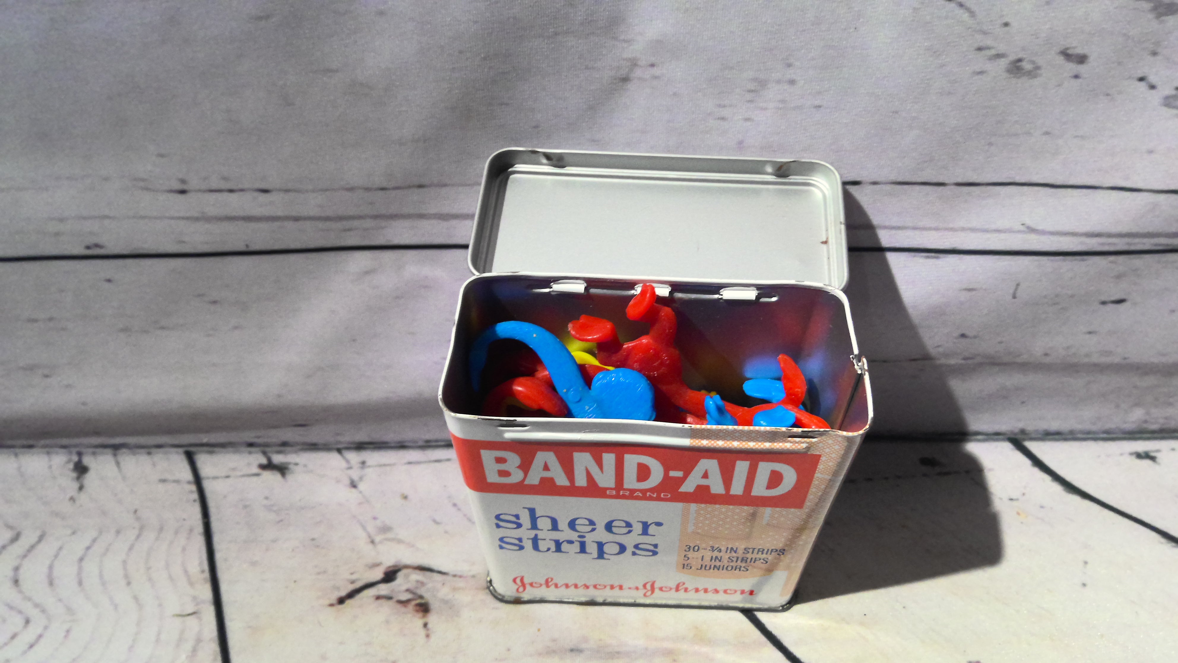 Band aid tin filled with monkeys